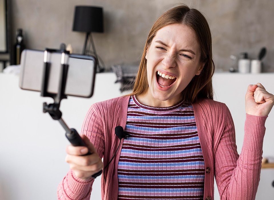 mulher segurando celular com pau de selfie